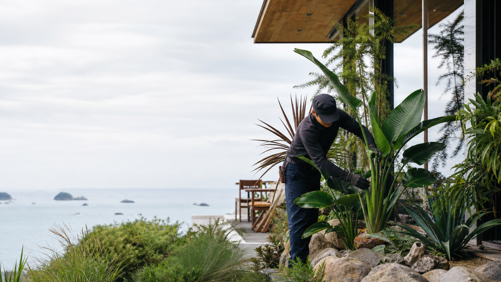 海辺の建物のそばで植栽を手入れする作業風景の施工イメージ